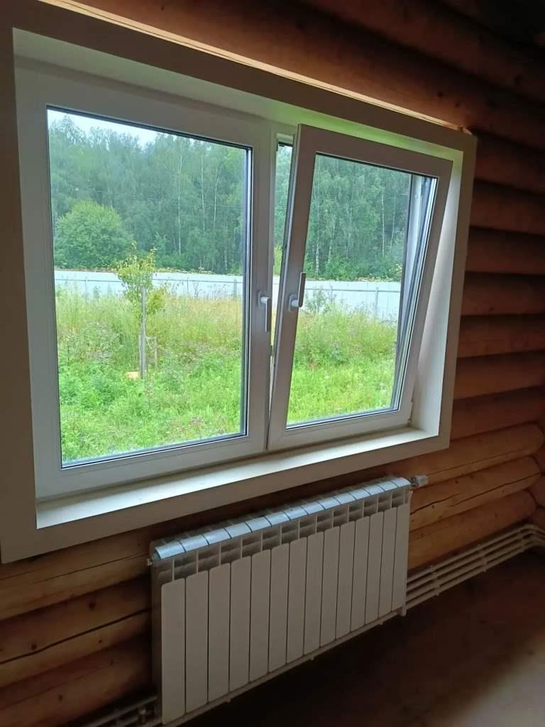 Белое окно с ламинированными откосами под дерево в бревенчатом доме